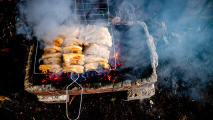 Pork is grilled on the coals