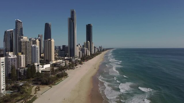 an aerial clip flying north along main beach at surfers paradise on a sunny morning on the gold coast of qld, australia