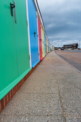 Colourful beach huts in a row leading to the lifeboat station on the seafront. copy space. 