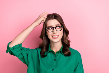 Photo of puzzled confused clever woman with wavy hairdo dressed green shirt look empty space finger on head isolated on pink background - obrazy, fototapety, plakaty