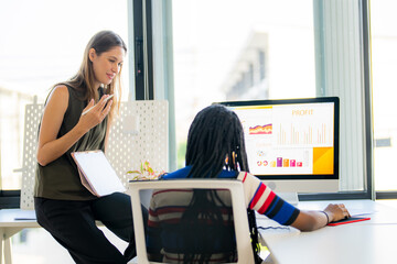 Two business woman working in her office.