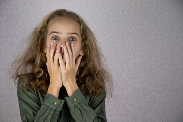 Frightened teenage girl covers her face with her hands. The concept of fear and horror in school...