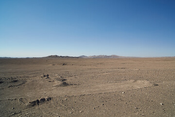 Fototapeta na wymiar Chile, Atacama desert - view of desert with hils in the back and tracks of industrial activity