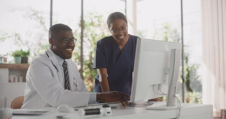 Health Care Medical Hospital. Happy African American Nurse and Black Doctor Having a Casual Conversation, Using Desktop Computer, Laughing and Smiling During a Break at Work