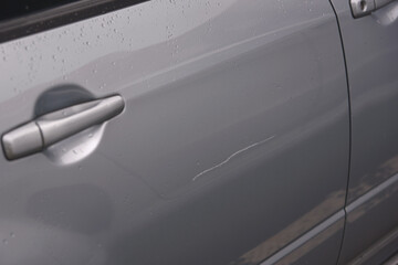 Сar door scratched, damage to paint and lacquer coat. Dent car scratch. Vandal scratched car with...