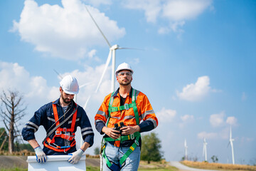 Wind turbine service engineer maintenance and plan for inspection at construction site, renewable electricity generator.