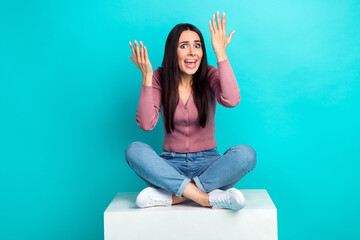 Photo of offended dissatisfied girl straight hairdo pastel cardigan sitting on cube complains isolated on vibrant teal color background - obrazy, fototapety, plakaty