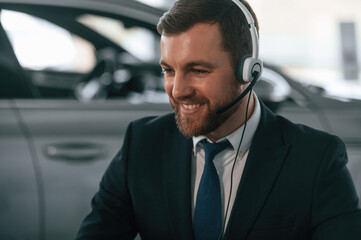 Man is sitting and working in the car showroom