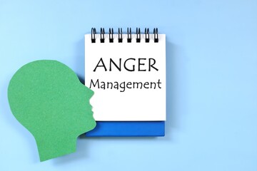 Anger management concept. Human head profile beside a notepad with written text.