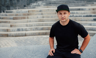 Young guy wearing black blank t-shirt and black cap. Mock-up for print. T-shirt template.