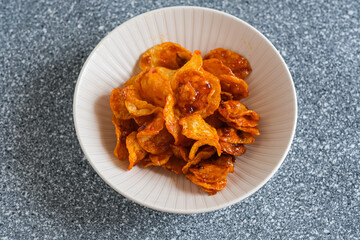 spicy potatoes chips in white plaste