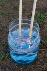Close up bubble maker wand along with a container of bubble soap