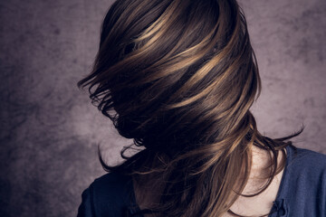 Model girl in the studio. Her face is covered by her hair.