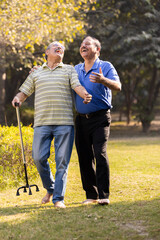 Obraz premium Two happy senior male friends spending leisure time at park