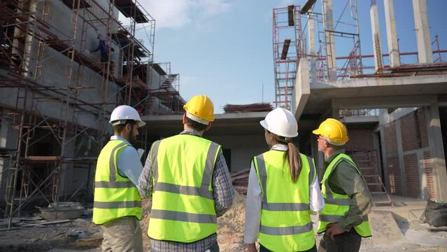 Construction engineer discussing and making plans with architect at construction site.