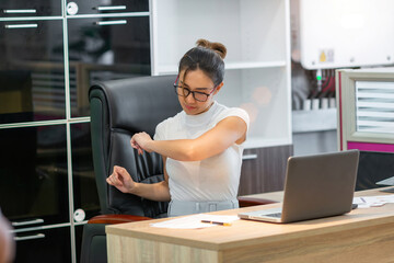 tired asian business woman stretch body. company employee hurt body prevent by stretch. beautiful exhausted young adult female worker person lean and stretching arm reduce pain from office syndrome