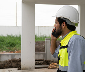 engineer talking on the phone Wear a helmet and safety vest.
