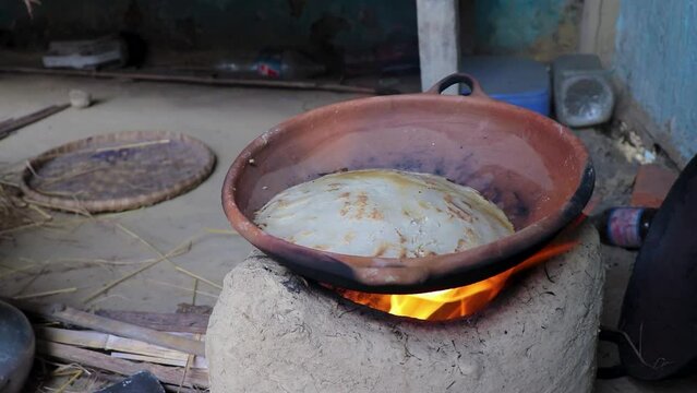 rice floor bread making in traditional soil vessels at wood fire from different angle