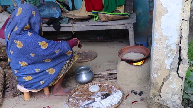 women making rice bread in traditional soil vessels at wood fire from different angle at village