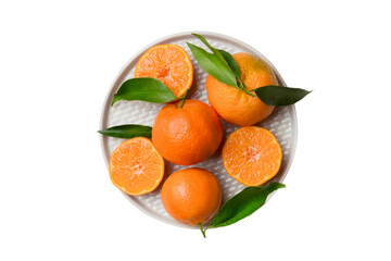 Fresh cutted clementines and whole mandarin over round plate isolated on white background. Food and drink ingredients preparing. healthy eating theme top view with copy space