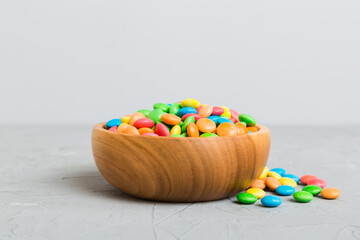 Multicolored candies in a bowl on a colored background. birthday and holiday concept. Top view with...