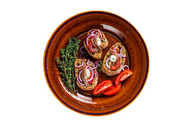 Spanish tapas on bread with olive oil, herbs, tomatoes and spicy anchovy fillets. Isolated,...