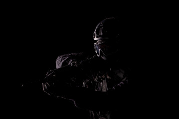 Spec ops police officer SWAT special forces  with a weapon in his hands. on a dark background. Law...