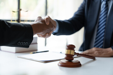Legal and justice concept Young asian businessman shaking hands with young lawyer or legal advisor after contracting business partnership agreement in real estate project and finance in the office.
