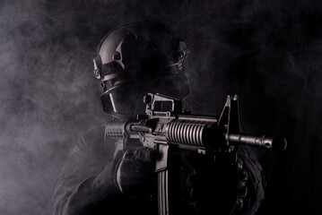 Spec ops police officer SWAT special forces  with a weapon in his hands. on a dark background. Law...