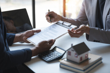 Young Asian home sales agents, insurance agents, and real estate agents offer young Asian entrepreneurs information on price conditions when signing a contract to buy rent house in the office.
