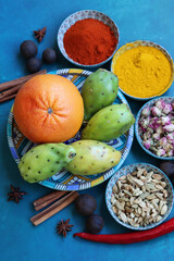 Top view photo of various spices on a blue table. Vivid background with copy space.  Food flavoring concept. 