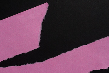 Pink torn paper piece isolated on a black background. Ripped blank paper with copy space for text.
