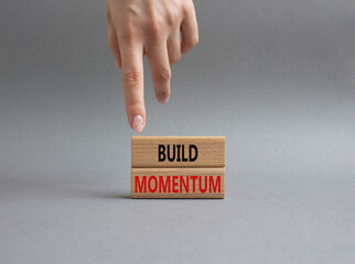 Build momentum symbol. Wooden blocks with words Build momentum. Beautiful grey background. Businessman hand. Business and Build momentum concept. Copy space.