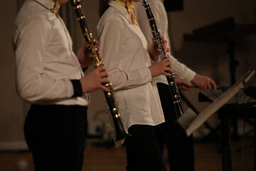 Fototapeta na wymiar A young musician standing in a band with a wind musical instrument plays the clarinet
