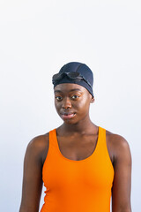 Black young woman looking at camera wearing swimsuit with plain white background