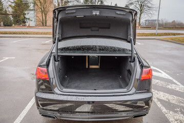 The car is parked with an open trunk. Rear view. Open empty trunk  modern sedan car. The car boot...