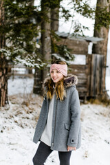 Glückliches lachendes hübsches Mädchen mit langen Haaren und Stirnband im Wald im Winter	mit Schnee