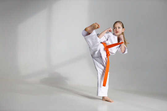 A strong kick by a little girl in a white kimono.
