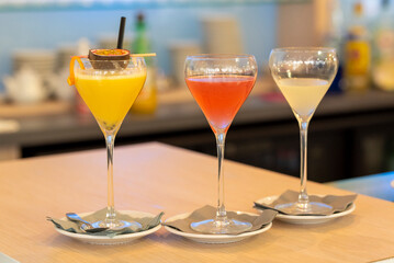 3 cocktails colorés servis sur le comptoir du bar d'un restaurant - gros plan