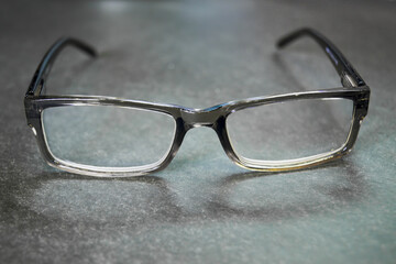 Corrective reading glasses on a dark gray background.