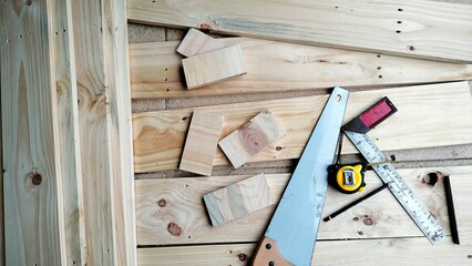 some pine planks being cut using a saw to make the interior of the house