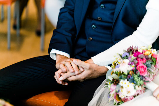 Brautpaar h&auml;lt H&auml;nde w&auml;hrend Trauung bei Hochzeit