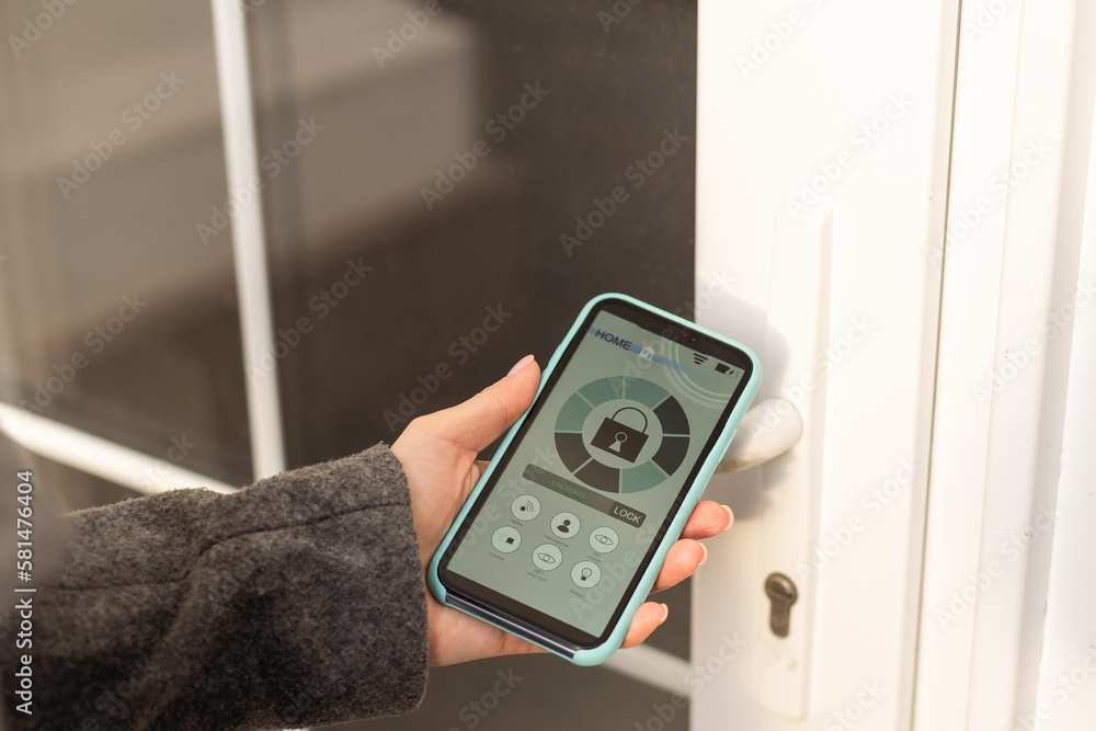 Poster woman locking smartlock on the entrance door using a smart phone. concept of using smart electronic 