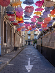 Fototapeta na wymiar colorful street decorated with colored umbrellas in Catania