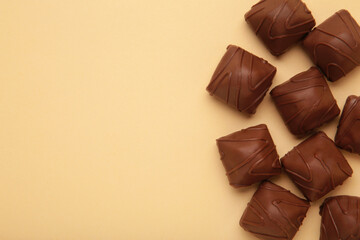 Chocolate candies on beige background. Top view