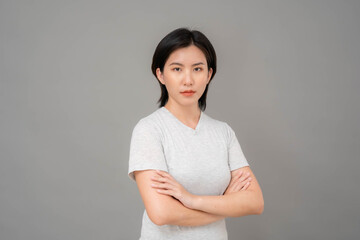 Obraz premium Portrait. A photo of an Asian woman standing with her arms folded in a stern look.