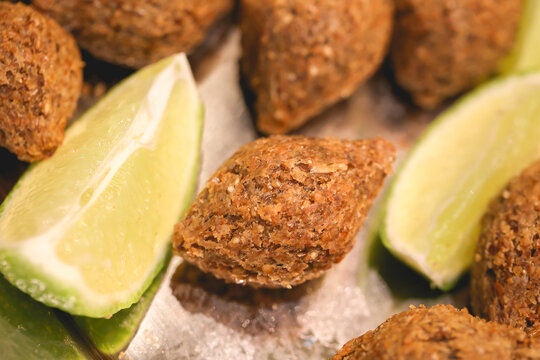 Quibe Frito. Pequenos quibes com peda&ccedil;os de lim&atilde;o servidos em uma travessa. Comida brasileira, Petisco, Salgado, Salgadinho.
