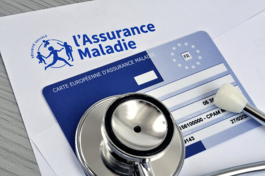 Stéthoscope posé sur une carte d'assurance maladie européenne et une feuille d'assurance maladie