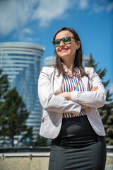 Outdoor Portrait of Confident Business Woman Posing over Business Center Buildings in Sunny Summer Day 