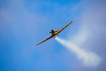 Small old plane in the air. Blue sky background.